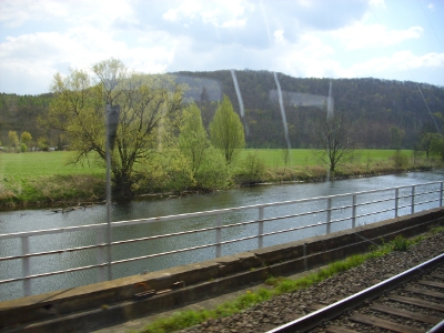 Farbfoto: Blick aus der fahrenden Eisenbahn auf die Saale im Saaletal auf der Fahrt von Halle nach Weimar, kurz nachem wir durch Bad Kösen gefahren waren, am Sonntag dem 22. April im Jahre 2012. Fotograf: Bernd Paepcke.