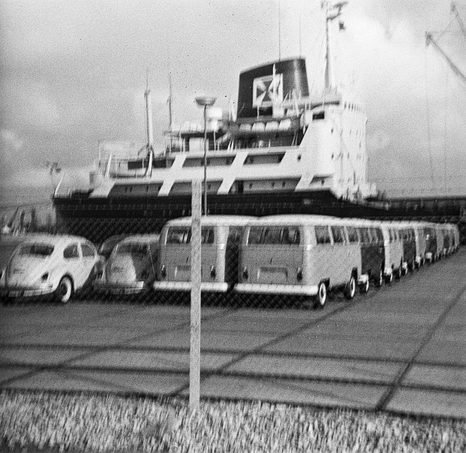 Foto von VW Käfern und VW Bussen vor einem Autotransport-Schiff im dem Emder Hafen aus dem Jahr 1967. Foto: Erwin Thomasius.